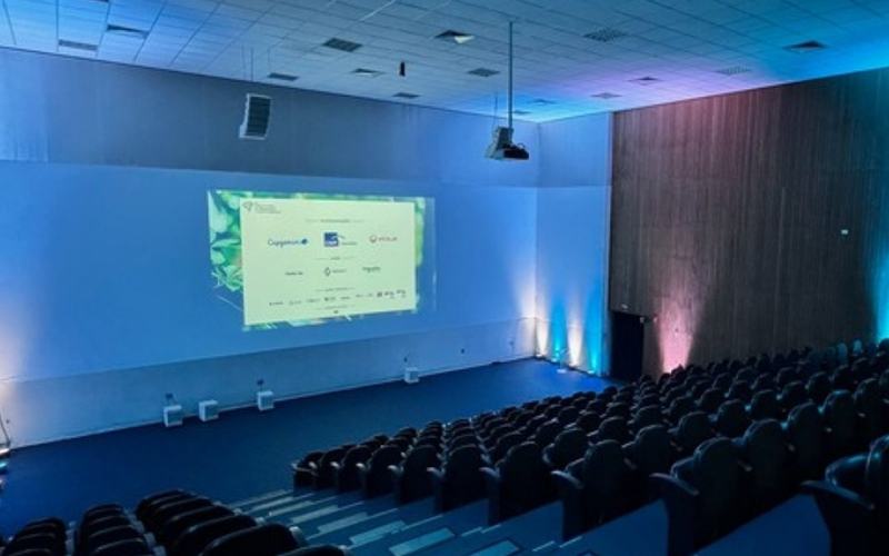 Sonorização para eventos em São Paulo: auditório preparado com projeção e iluminação azul antes da chegada do público