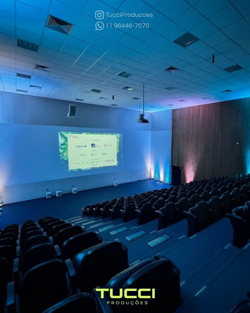 Sonorização para eventos em São Paulo: auditório preparado com projeção e iluminação azul antes da chegada do público