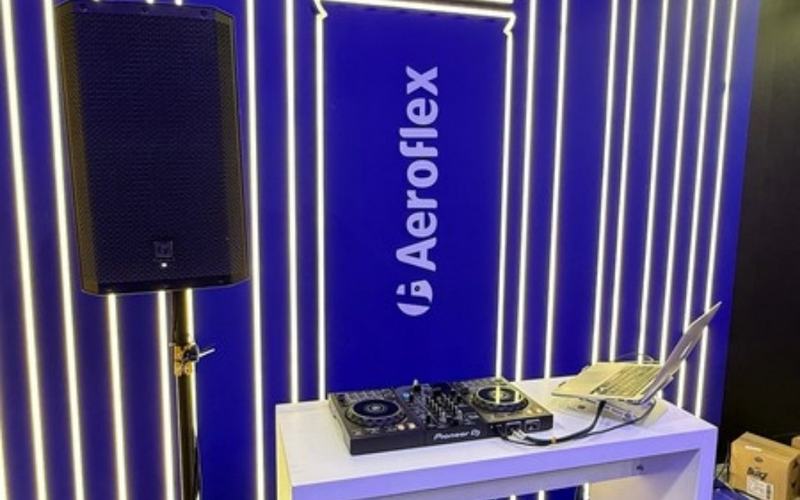 Sonorização para eventos em São Paulo: caixa de som em pedestal e mesa de DJ em estande de feira