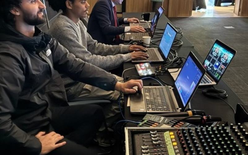 Sonorização para eventos em São Paulo: equipe técnica operando mesa de som e notebooks durante evento