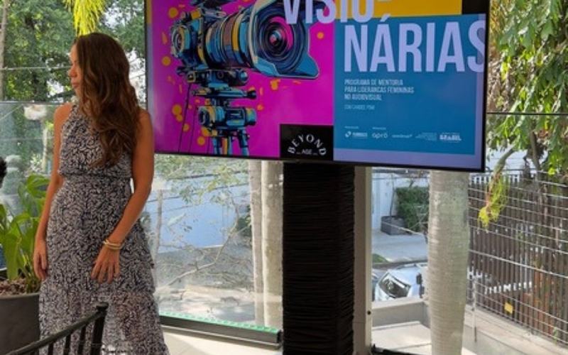 Locação de TV para eventos em São Paulo: tV em pedestal ao lado da palestrante em evento em área externa