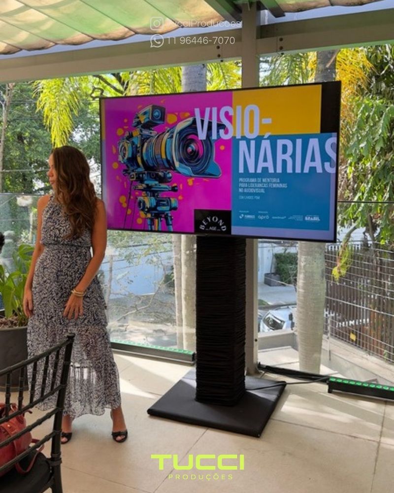 Locação de TV para eventos em São Paulo: tV em pedestal ao lado da palestrante em evento em área externa