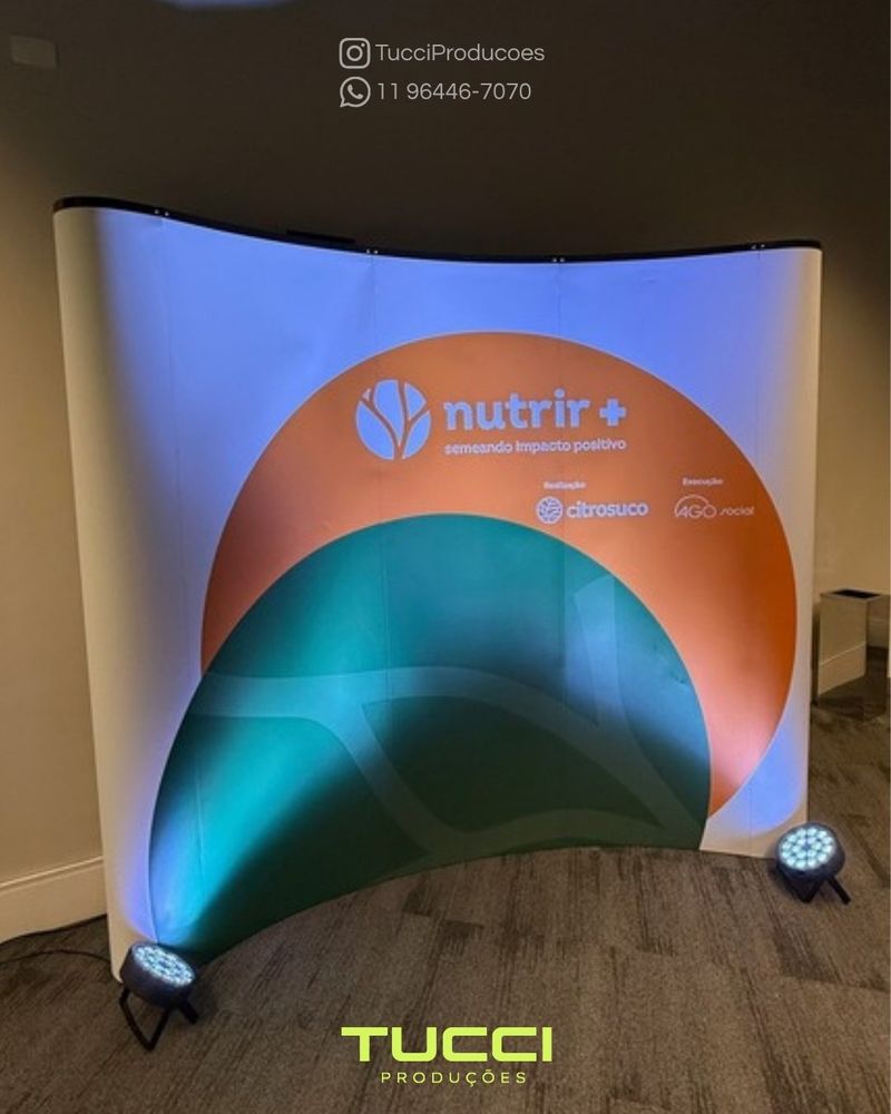 Cenografia para eventos em São Paulo: painel cenográfico curvo iluminado por refletores de LED
