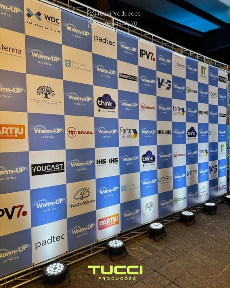 Iluminação para eventos em São Paulo: painel de patrocinadores iluminado por refletores de LED no chão