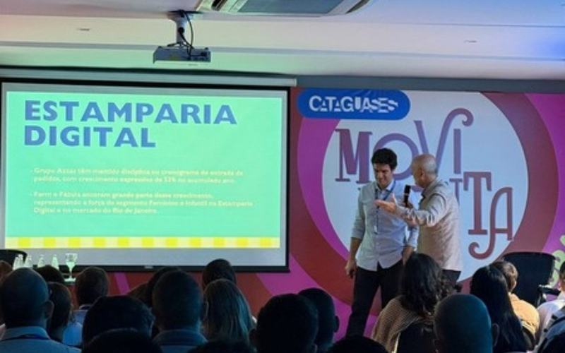 Audiovisual para convenções em São Paulo: palestrante com microfone ao lado da projeção em convenção de vendas