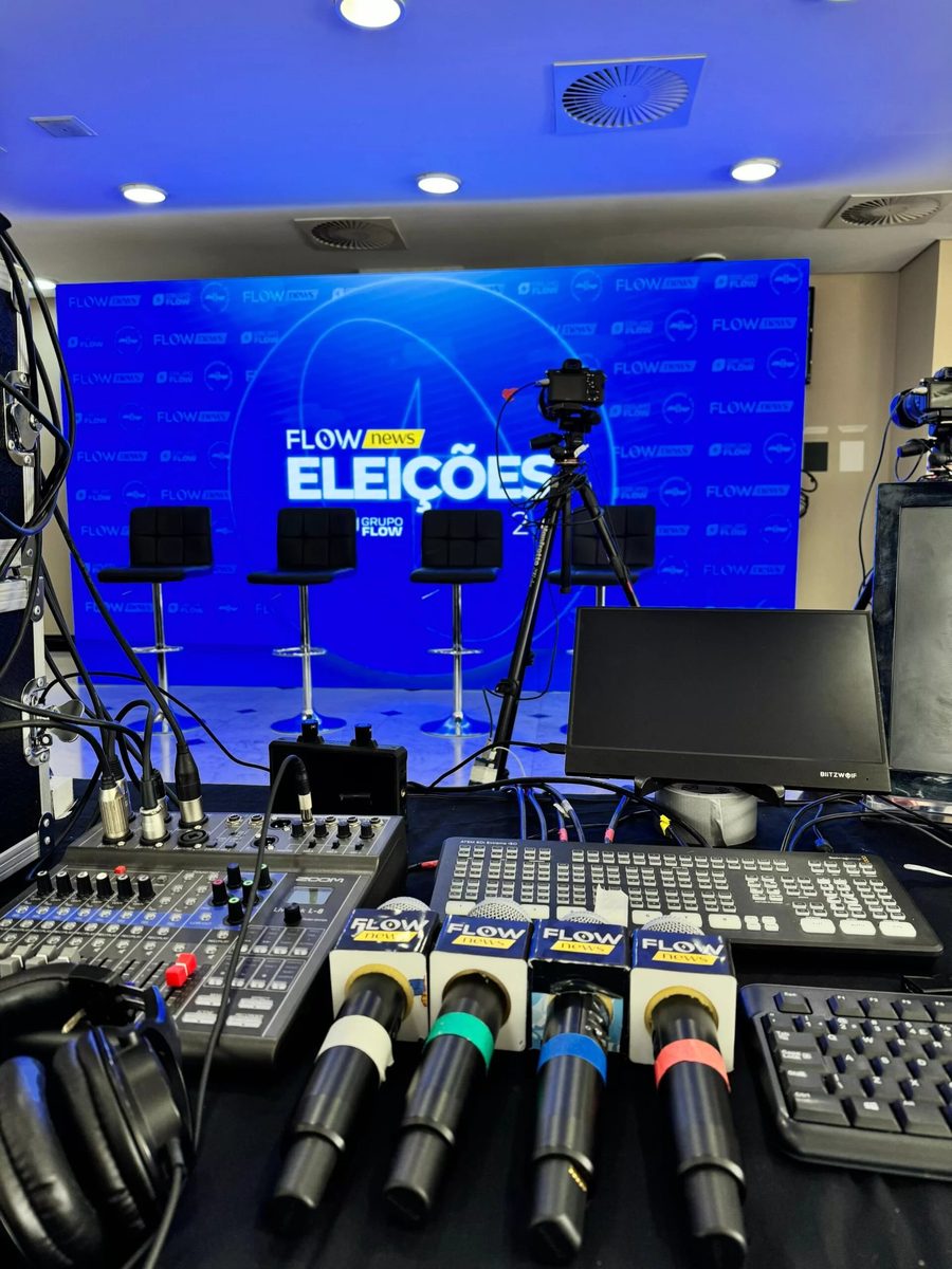 Estrutura de transmissão ao vivo com microfones, mesa e telão